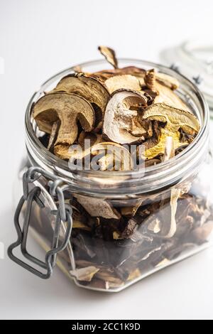 Champignons séchés dans un pot en verre sur fond blanc Banque D'Images