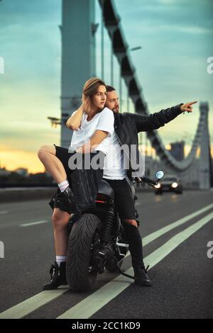 Biker homme et fille se tient sur la route et regarde dans la distance. L'amour et le concept romantique Banque D'Images