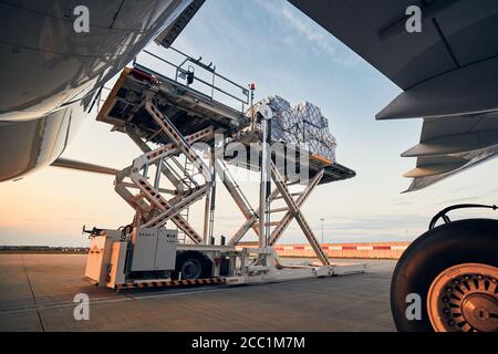 Préparation avant le vol. Chargement de conteneurs de fret dans un avion à l'aéroport. Banque D'Images