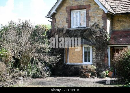 L'herbe brûlée et monté sur les fenêtres sur une propriété à côté de l'A4 près de Derry Hill, Calne, Wiltshire, où quatre jeunes hommes sont morts après que la voiture dans laquelle ils se trouvaient s'est écrasé dans une maison et a pris le feu. Banque D'Images