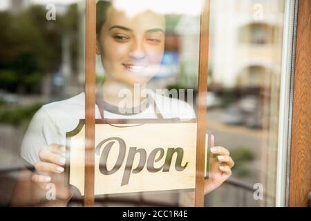 Panneau ouvert sur le verre avec reflet du café de rue ou du restaurant. Pandémie de coronavirus nouvelles règles de sécurité. Ouverture après la période de quarantaine. Récupération après isolement pour les petites entreprises. Gros plan. Banque D'Images