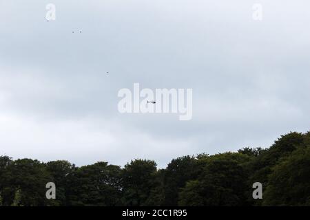 Hélicoptère de police survolant Tippett House au milieu d'une forêt à Smithills, en Angleterre Banque D'Images