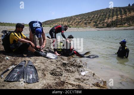 Idlib, Syrie. 17 août 2020. Des membres de la défense civile syrienne, également connus sous le nom de casques blancs, équipent des volontaires lors d'une session d'entraînement de plongée sous-marine dans un lac d'Idlib. Les casques blancs sont en train de former leurs bénévoles sur les compétences de sauvetage en eau pour préparer une équipe de plongeurs d'urgence à aider dans les opérations de recherche et de sauvetage pour les cas de noyade. Credit: Aras Alkharboutli/dpa/Alamy Live News Banque D'Images