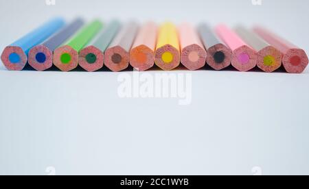 Pile de différents crayons de couleur en bois éparpillés sur un arrière-plan du livre blanc Banque D'Images