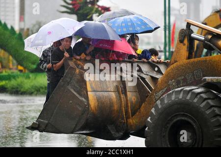 (200817) -- LONGNAN, 17 août 2020 (Xinhua) -- les personnes piégées sont transférées par un bulldozer dans le district de Wudu, dans la ville de Longnan, dans la province de Gansu, dans le nord-ouest de la Chine, le 17 août 2020. Les pluies torrentielles d'une semaine dans la province de Gansu ont conduit à un affluent du fleuve Yangtze qui s'écoule au-dessus du niveau de danger alors que les autorités locales combattent diverses catastrophes provoquées par la pluie, notamment des torrents de montagne, des glissements de terrain et des coulées de boue. Lundi, les pluies ont endommagé 3,303 km de routes dans la ville de Longnan, perturbant la circulation sur 497 routes. Plus de 38,000 personnes ont été déplacées à Longnan. (Réceptacle Xinhua/Chen) Banque D'Images