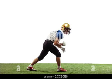 En action. Joueur américain de football isolé sur fond blanc studio avec copyspace. Sportif professionnel pendant le jeu en action et en mouvement. Concept de sport, mouvement, réalisations. Banque D'Images