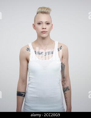 Portrait de jeune femme avec des tatouages against white background Banque D'Images