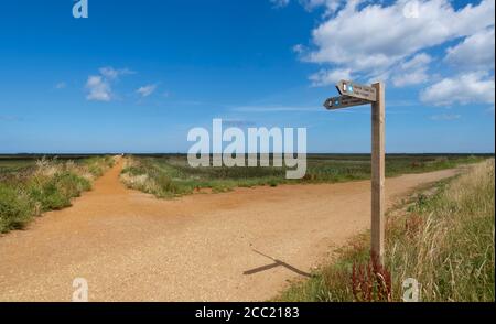 Le Norfolk Coast Path à CLEY à côté de la mer, Norfolk, Royaume-Uni. Le chemin de gauche traverse CLEY Marshes vers la mer du Nord. Banque D'Images