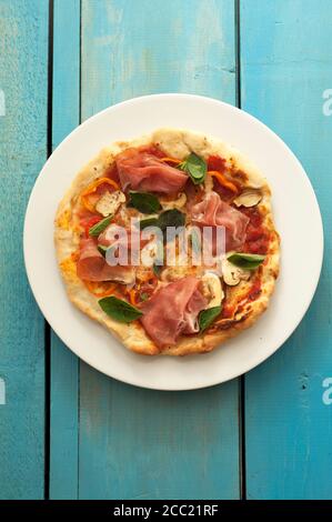 Assiette de jambon, pizza au basilic, champignons et mozzarella sur table, Close up Banque D'Images