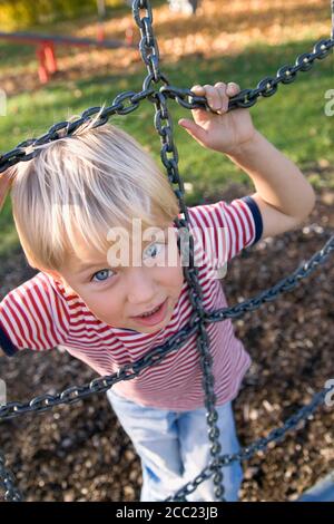 Little Boy (4-5) holding metal monkey cordes, elevated view Banque D'Images