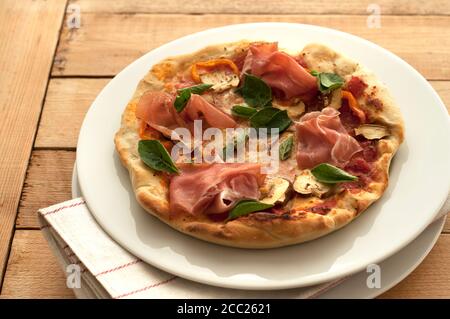 Assiette de jambon, pizza au basilic, champignons et mozzarella sur table, Close up Banque D'Images