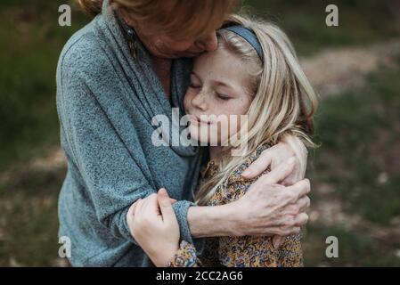 Image détaillée d'une jeune fille embrasée par une grand-mère âgée Banque D'Images