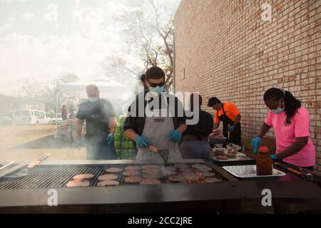 Cedar Rapids, Iowa, États-Unis. 16 août 2020. 16 août 2020 : des volontaires de Iowa Premium à Tama, Iowa, servent des repas chauds pour les résidents des appartements Cedar Terrace. Cedar Terrace Apartments, une communauté de nombreux réfugiés dans leur propre pays, a été dévastée lors de la tempête qui a frappé la région le lundi 10 août. De nombreux bâtiments sont condamnés, de sorte que les résidents dorment dehors dans des tentes. Après que les nouvelles locales aient été mises en évidence, des dons arrivent et le service des incendies tente de mettre autant de personnes qu'elles le peuvent dans des abris. Malheureusement, beaucoup d'entre eux refusent de laisser leurs biens à la demande Banque D'Images