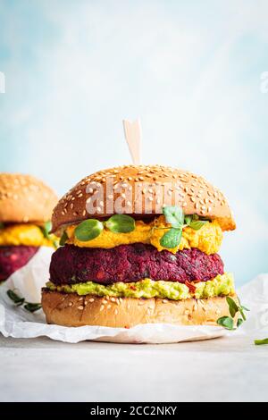 Hamburger végétalien avec côtelette de betteraves, sauce patate douce et guacamole. Banque D'Images