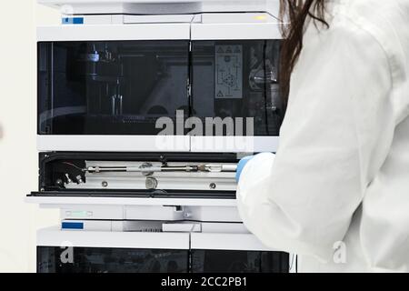 Chimiste ou scientifique changeant une colonne sur HPLC de chromatographie liquide haute performance pour la séparation de composés organiques. Chimie analytique Banque D'Images