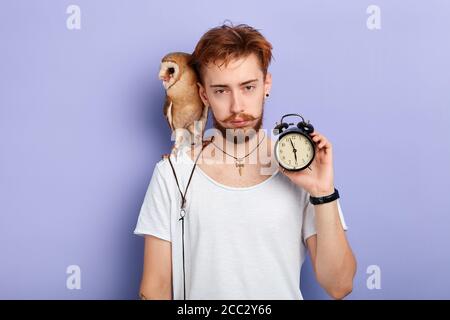 un homme endormi veut dormir. portrait en gros plan, arrière-plan bleu isolé, prise de vue en studio. sentiment négatif et émotion, expression faciale Banque D'Images