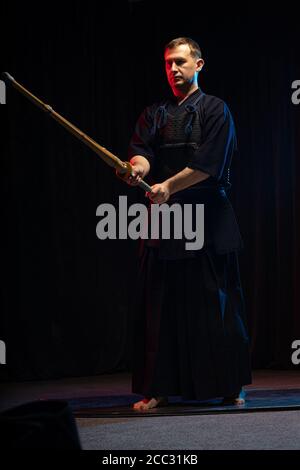 portrait d'un homme caucasien fort kendo combattant avec bokuto. kendo guerrier mâle tenant sabre samouraï katana Banque D'Images