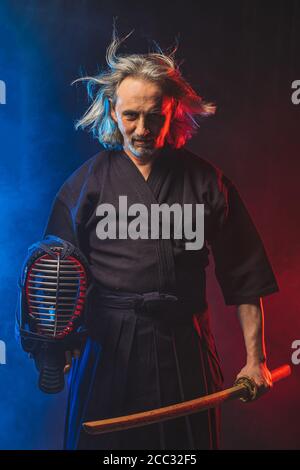 kendo combat guerrier en robe traditionnelle sur fond fumé, avant les compétitions. Homme passionné par l'art martial traditionnel japonais entraînement, puissance. Banque D'Images