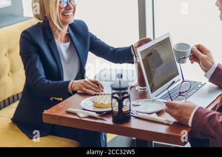 rire femme travaillant avec un client. gros plan vue de côté photo. espace de copie. partenaires d'humeur positive parler d'une affaire Banque D'Images