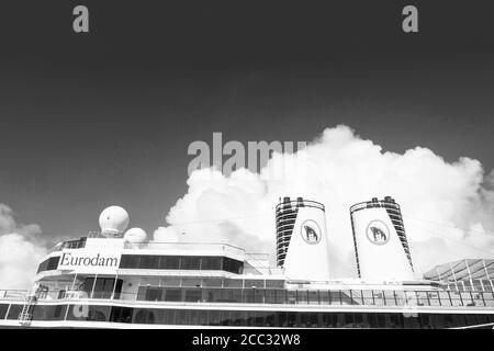 Miami, États-Unis - 31 décembre 2015 : ponts supérieurs et entonnoirs doubles d'Eurodam. Façade du bateau de croisière sur ciel bleu nuageux. Rangées de fenêtres et de balcons. Transport maritime. Aventure et découverte. Banque D'Images