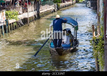 Un homme conduit un bateau de gondole avec touriste dans un canal d'eau au marché flottant Khlong Lat Mayom, Thaïlande. Banque D'Images