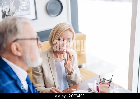 belle femme élégante montrant son mari de montrer sa bouche après avoir mangé du gâteau. photo de gros plan Banque D'Images