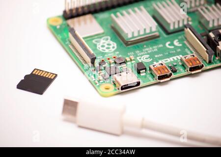 Kiev, Ukraine - 13 août 2020: cordon usb de type 3 avec une carte micro sd située à côté d'un ordinateur monocarte framboise pi 4 sur fond blanc Banque D'Images