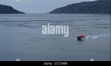 Un petit bateau à moteur de tourisme transportant des passagers lors d'une croisière d'agrément autour des îles dans le détroit du Jura par un jour d'été calme Banque D'Images