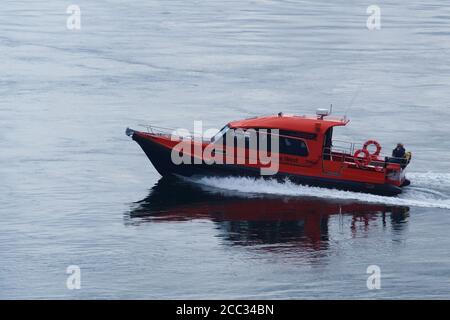 Un petit bateau à moteur de tourisme transportant des passagers lors d'une croisière d'agrément autour des îles dans le détroit du Jura par un jour d'été calme Banque D'Images