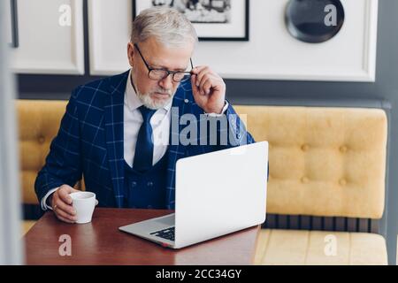 travailleur indépendant mature concentré sur son travail dans le café. gros plan photo.creative homme d'affaires développant un plan Banque D'Images