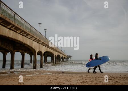 Deux femmes avec planches de surf sur la plage de Bournemouth Banque D'Images