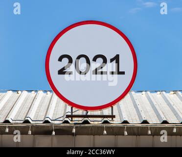 Un panneau d'affichage circulaire portant le numéro 2021 est installé sur un toit. Salutation pour le nouvel an 2021. Banque D'Images