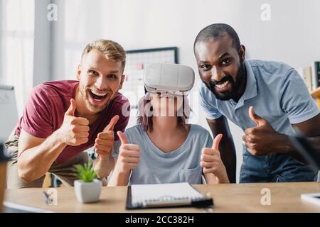 Objectif sélectif des professionnels multiethniques avec les micro-casques vr bravo à l'appareil photo au bureau Banque D'Images