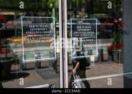 17 août 2020 : une femme portant un masque de protection individuelle se reflète dans la porte du Manhattan Mall. Un panneau explique la fermeture en raison d'une commande de NY State Executive car les centres commerciaux de New York restent fermés jusqu'à nouvel ordre à Manhattan, New York. Crédit obligatoire : Kostas Lymperopoulos/CSM Banque D'Images