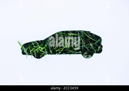 Vue de dessus du panneau de voiture et herbe verte sur fond blanc, concept écologique Banque D'Images