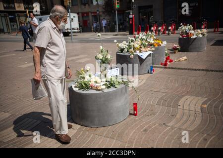 Un homme observe des hommages aux victimes de l'attaque de Barcelone. Trois ans après l'attaque de Barcelone, un hommage aux victimes est rendu à Las Ramblas. Banque D'Images