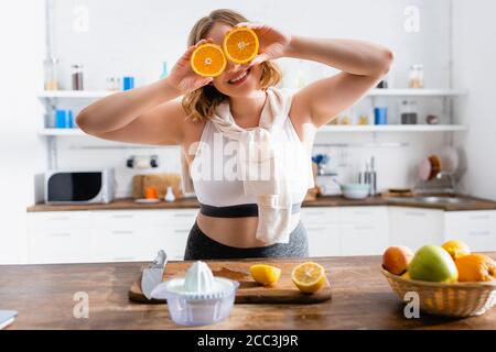 foyer sélectif de la femme couvrant les yeux avec des moitiés d'oranges Banque D'Images