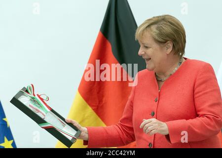 18 août 2020, Rhénanie-du-Nord-Westphalie, Düsseldorf: La chancelière Angela Merkel (CDU) regarde une photographie aérienne de Templin, qu'elle a reçue en cadeau du gouvernement de Rhénanie-du-Nord-Westphalie. Merkel a grandi à Templin et est allée à l'école. Le Chancelier participe à une réunion du cabinet du gouvernement du Rhin-Nord-Westphalie et se rend à la mine de charbon Zollverein à Essen. Photo: Federico Gambarini/dpa-pool/dpa Banque D'Images