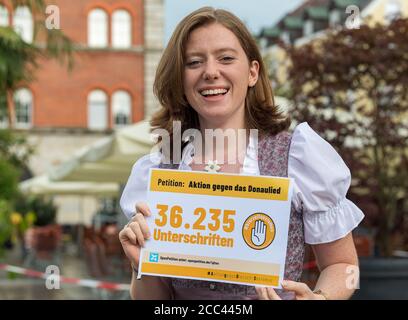 18 août 2020, Bavière, Passau: Corinna Schütz, une étudiante, est sur le point de commencer un rassemblement de militants anti-Donaulied pour fermer la pétition en ligne dans le centre-ville et a une affiche avec le numéro 36,235, qui représente les signatures d'une pétition contre le Danube Song. Le groupe veut s'assurer que la chanson du Danube ne se joue plus dans les tentes de bière à Passau et fait campagne contre le sexisme dans les festivals publics. Dans les trois mois qui ont suivi le début de l'action, les initiateurs de Passau ont recueilli environ 36,000 voix de leurs partisans. Photo: Peter Kneffel/dpa Banque D'Images