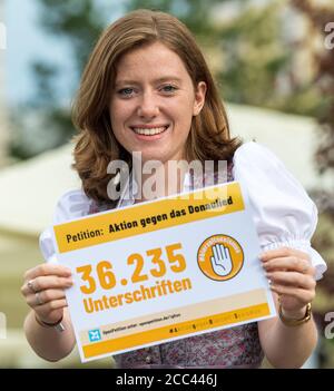 18 août 2020, Bavière, Passau: Corinna Schütz, une étudiante, est sur le point de commencer un rassemblement de militants anti-Donaulied pour fermer la pétition en ligne dans le centre-ville et a une affiche avec le numéro 36,235, qui représente les signatures d'une pétition contre le Danube Song. Le groupe veut s'assurer que la chanson du Danube ne se joue plus dans les tentes de bière à Passau et fait campagne contre le sexisme dans les festivals publics. Dans les trois mois qui ont suivi le début de l'action, les initiateurs de Passau ont recueilli environ 36,000 voix de leurs partisans. Photo: Peter Kneffel/dpa Banque D'Images