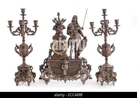 Studio photo de l'horloge antique en bronze et de deux chandeliers sur fond blanc. Europe de l'Ouest. 19e siècle Banque D'Images