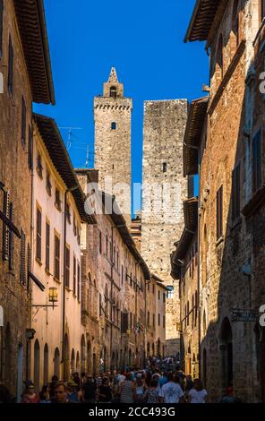Vue parfaite de la rue principale via San Giovanni avec la plus haute tour Torre Grossa en arrière-plan de la ville médiévale de San Gimignano, Toscane,... Banque D'Images