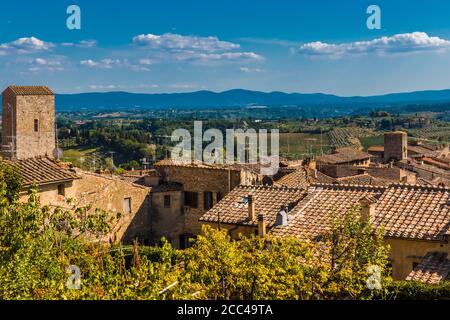 Vue parfaite sur le toit de la ville médiévale de San Gimignano, surplombant la magnifique campagne. Une vallée agricole typique en Toscane... Banque D'Images