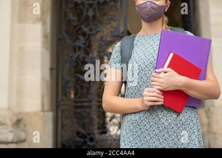 Gros plan d'une étudiante féminine debout à l'extérieur du collège ou de l'université Bâtiment portant un masque facial pendant la pandémie Covid-19 Banque D'Images