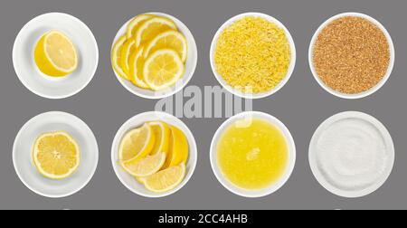 Citrons frais et transformés dans des bols en verre blanc, sur fond gris. Moitiés de citron, quartiers, tranches, zeste de citron fraîchement râpé et séché, jus et acide citrique. Banque D'Images