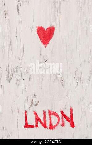 Un gros plan de Graffiti disant Love London dessiné à la main En rouge sur UNE palissade en bois peint en blanc Banque D'Images