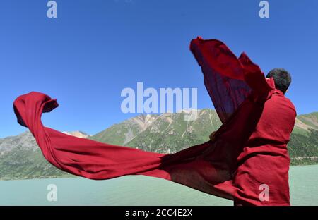 (200818) -- BEIJING, le 18 août 2020 (Xinhua) -- UN moine est situé près d'un lac d'un parc national de zones humides dans la ville de Nagqu, dans le sud-ouest de la Chine, région autonome du Tibet, le 17 août 2020. (Xinhua/Chogo) Banque D'Images