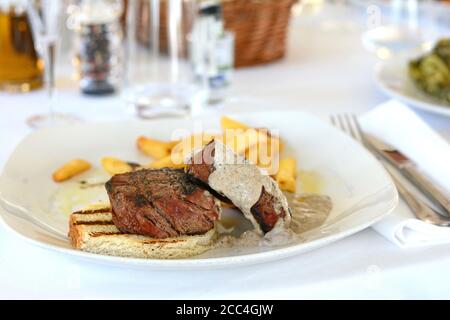 Steak de bœuf rôti moyen avec une sauce aux truffes. Steak grillé avec pommes de terre tard. Banque D'Images