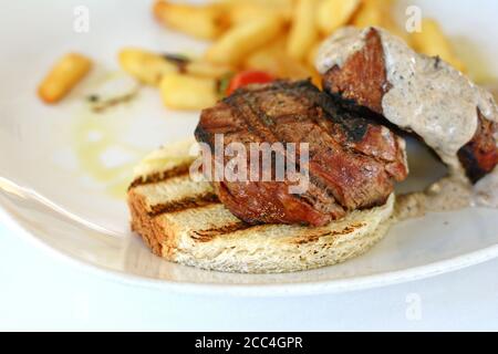 Steak de bœuf rôti moyen avec une sauce aux truffes. Steak grillé avec pommes de terre tard. Banque D'Images