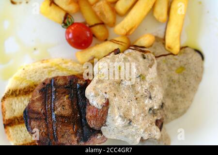 Steak de bœuf rôti moyen avec une sauce aux truffes. Steak grillé avec pommes de terre tard. Banque D'Images